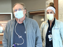 A masked Carl and his therapist standing in a hospital room