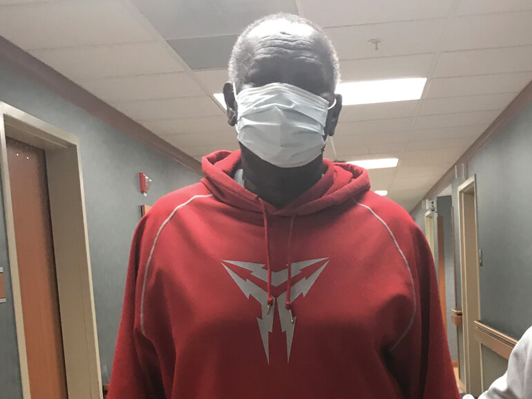 Gordon wearing a red pull-over hoodie and Covid mask.